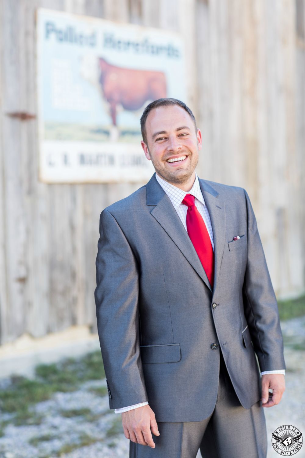 Picture of smiling groom in shiny grey suit at his wedding at Star Hill Ranch Hill Country wedding venue.