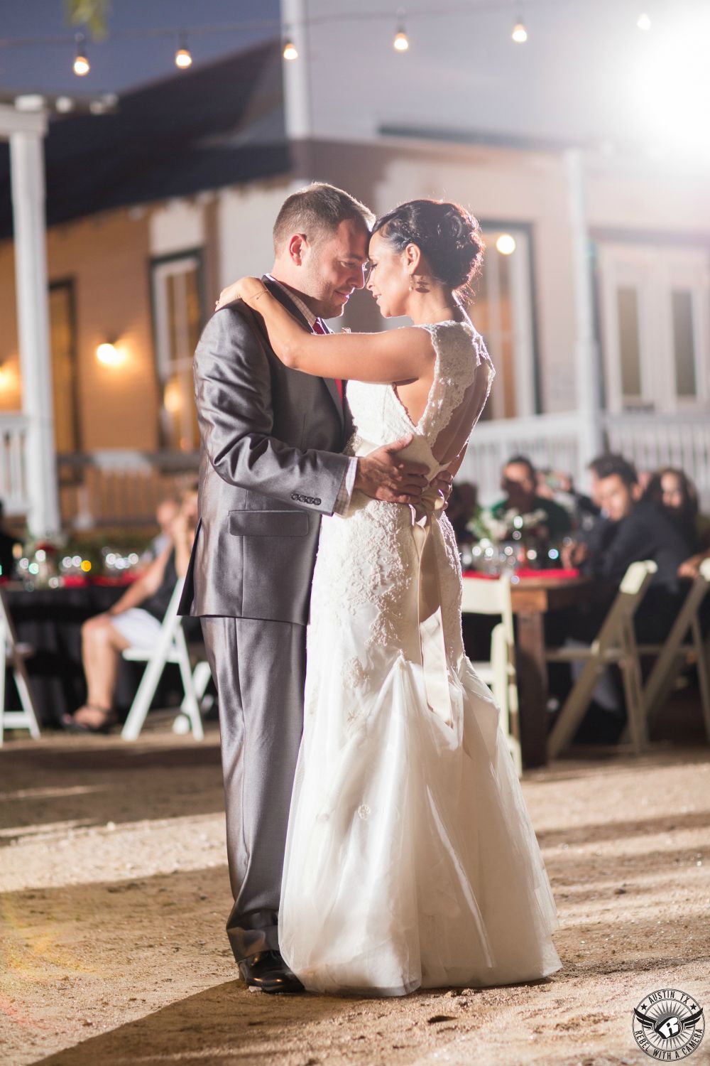 Picture of bride and groom dancing their first dance in the open air outside at their wedding reception at Star Hill Ranch Hill Country wedding venue taken by Austin wedding photographer.