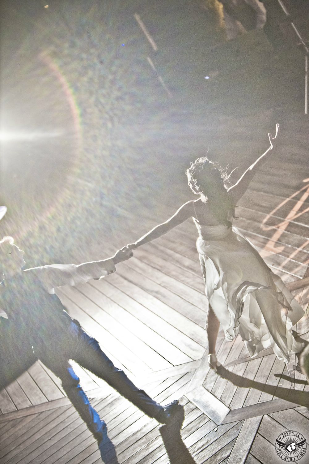 Dynamic picture of bride and groom's Dancing with the Stars first dance routine on the lower deck at Nature's Point Austin weddding venue taken by Austin wedding photographer.