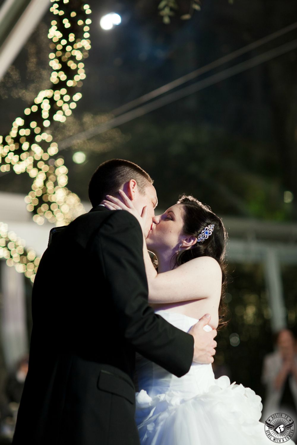Dramatic image of bride and groom kissing on their wedding day during their first dance at their wedding reception at the Allan House Austin wedding venue by Austin wedding photographer.