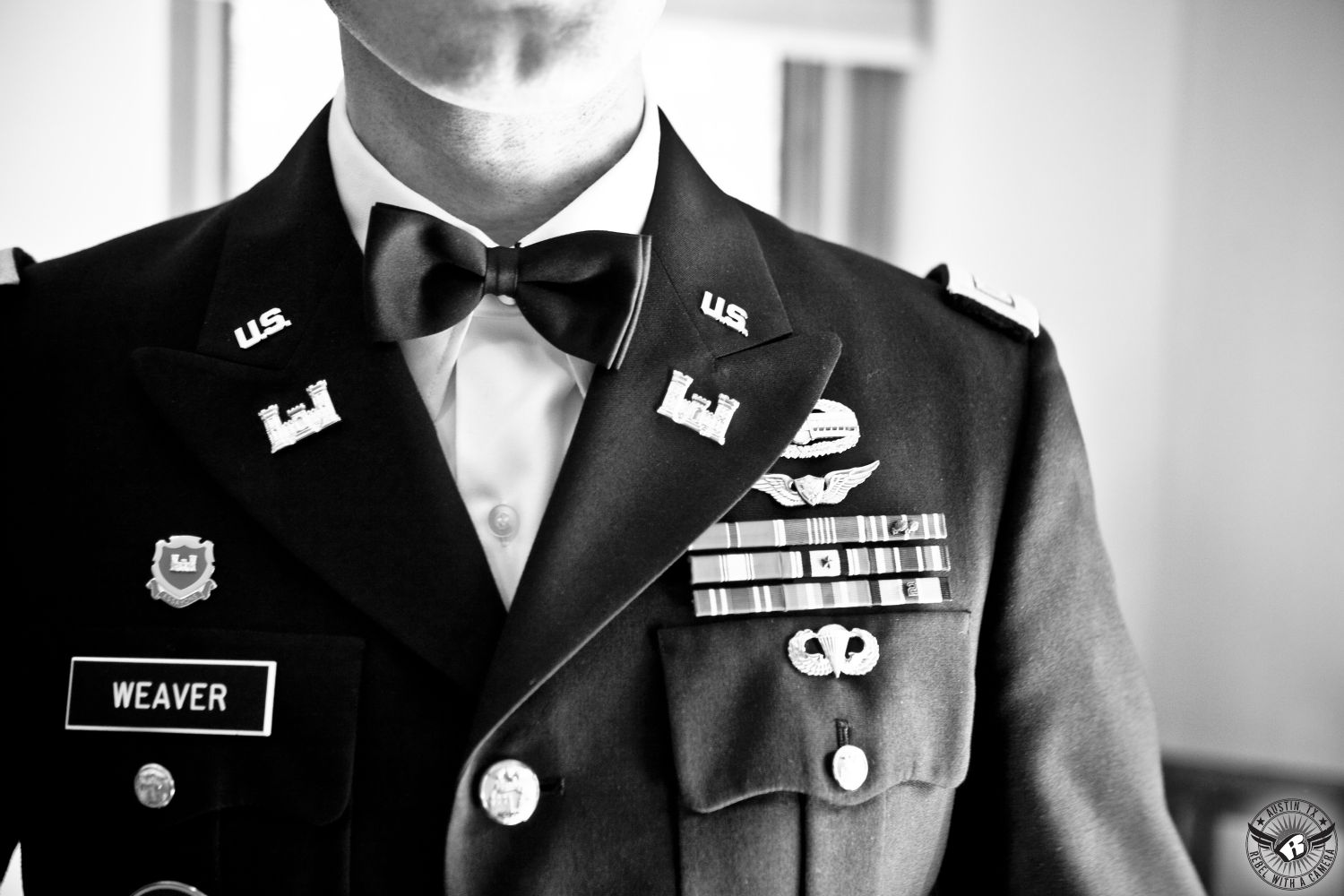 Black and white image of chest of groom in military uniform with black bowite and all his medals in the groom's room at Hamilton Twelve wedding venue in the HIll Country in Texas taken by Austin wedding photographer