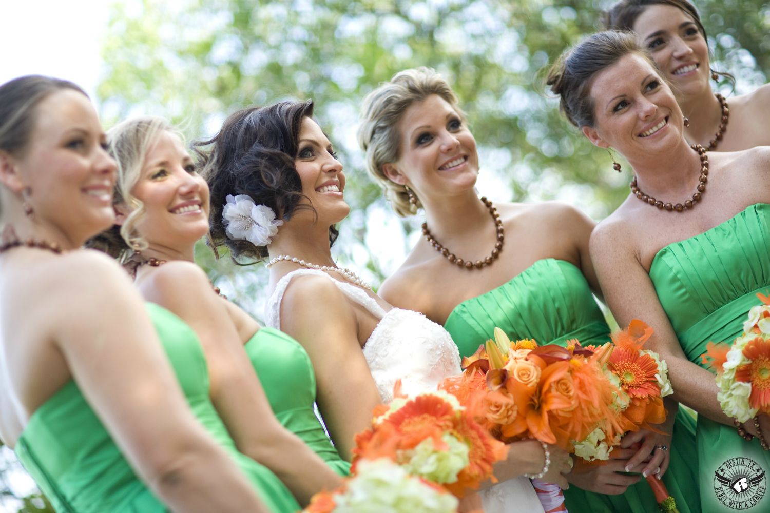 Austin wedding photography of austin wedding coordinator, Lindsay Blackwell, with makeup by Maris Malone Calderon on her wedding day with her bridesmaids in green dress and orange floral bouquets by Photosynthesis Austin wedding florist at Nature's Point Austin wedding venue.