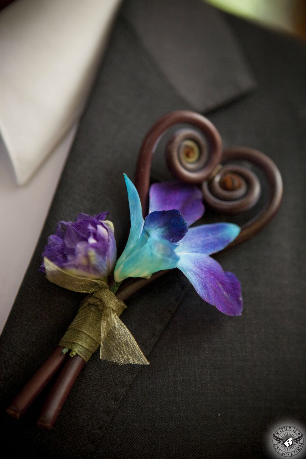 Austin wedding photography of heart shaped Monkey Tail and purple blue orchid groom's boutonniere by Zuzu's Petals at the Central Texas wedding venue, Kindred Oaks.