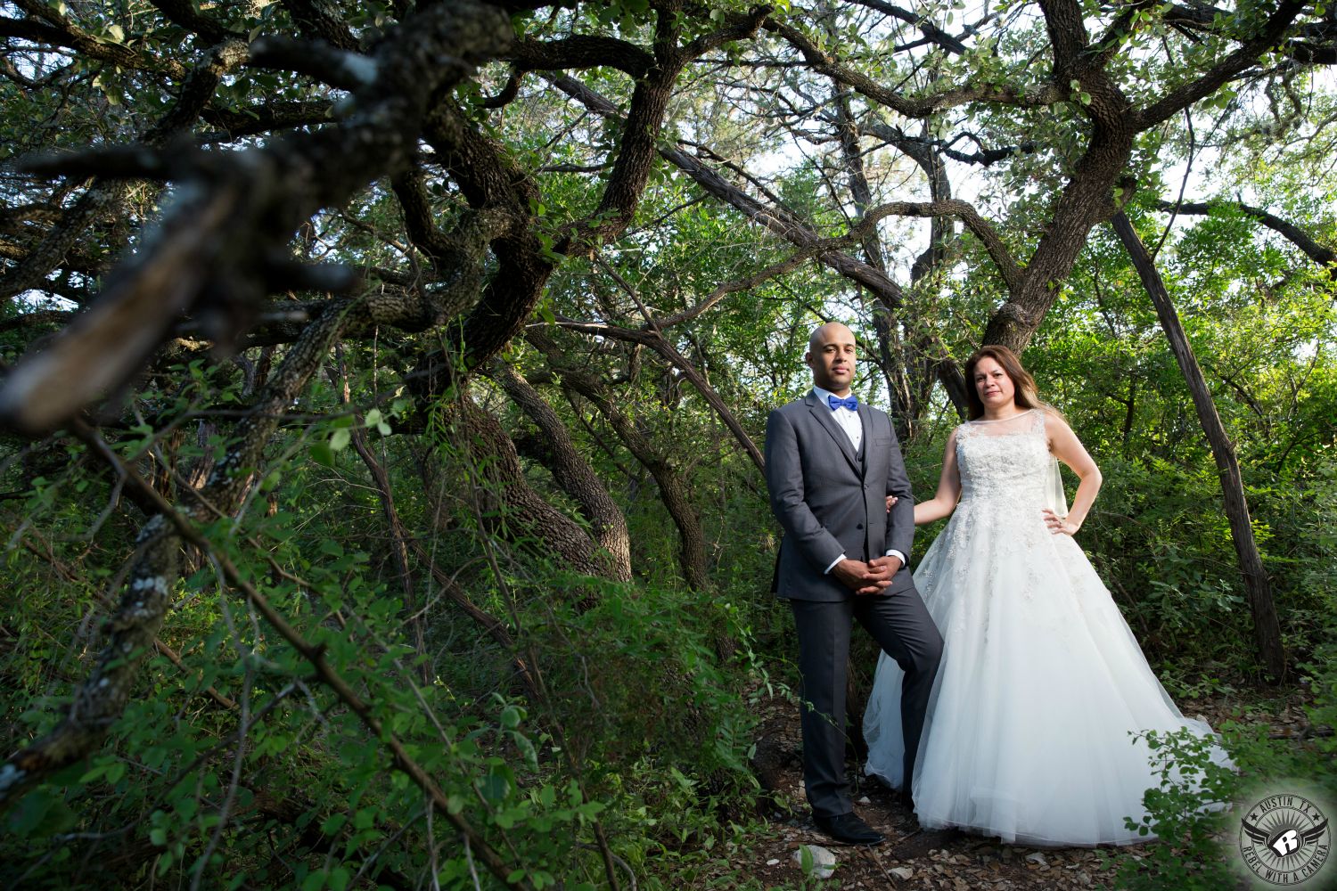 Picture of bride and groom posing dramatically in the trees at Mount Bonnell druing their day after shoot after their wedding in Austin by Austin wedding photographer Rebel with a Camera.