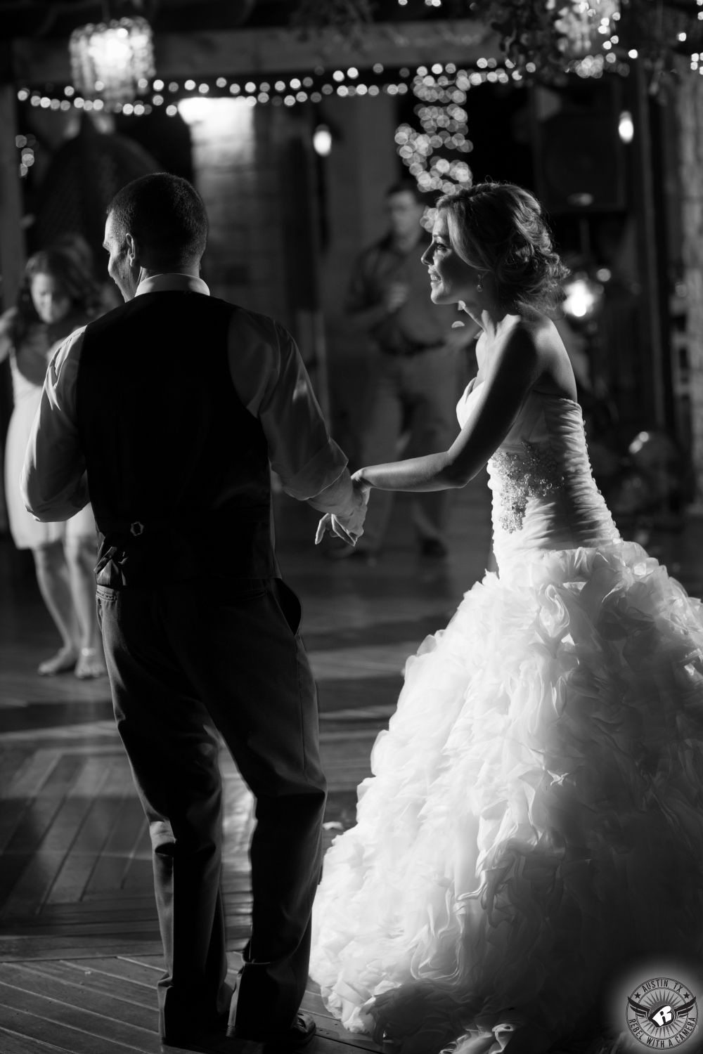 Dramatic black and white image of bride and groom on the dance floor at Kindred Oaks wedding venue in Central Texas taken by Austin wedding photographer, Rebel with a Camera.