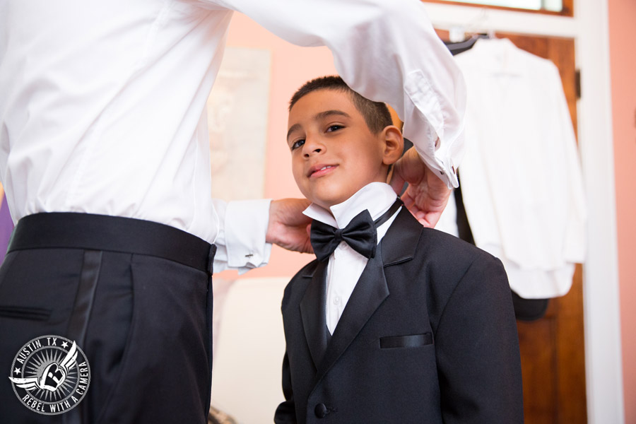 Taylor Mansion wedding photo groom ties bowtie for ring bearer in groom's room