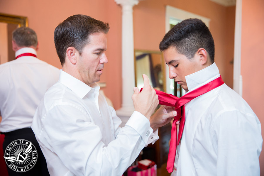 Taylor Mansion wedding photo groom ties bowtie for groomsman in groom's room