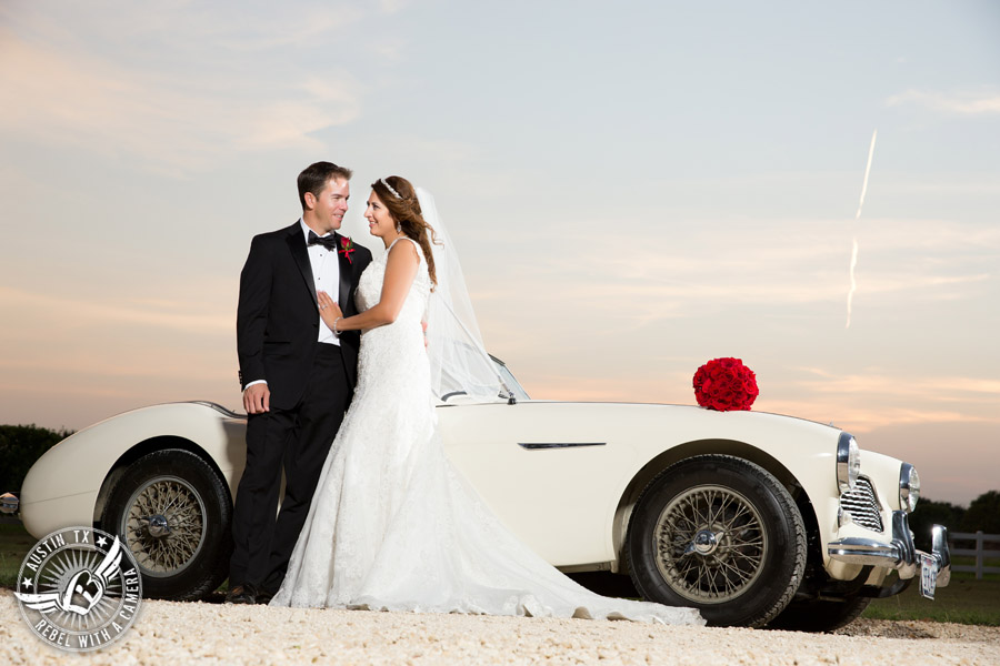 Taylor Mansion wedding photo of bride and groom with white convertible and red rose bouquet