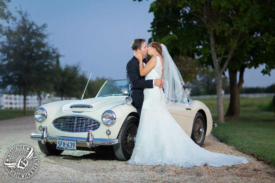 Taylor Mansion wedding photo of bride and groom kissing with white convertible