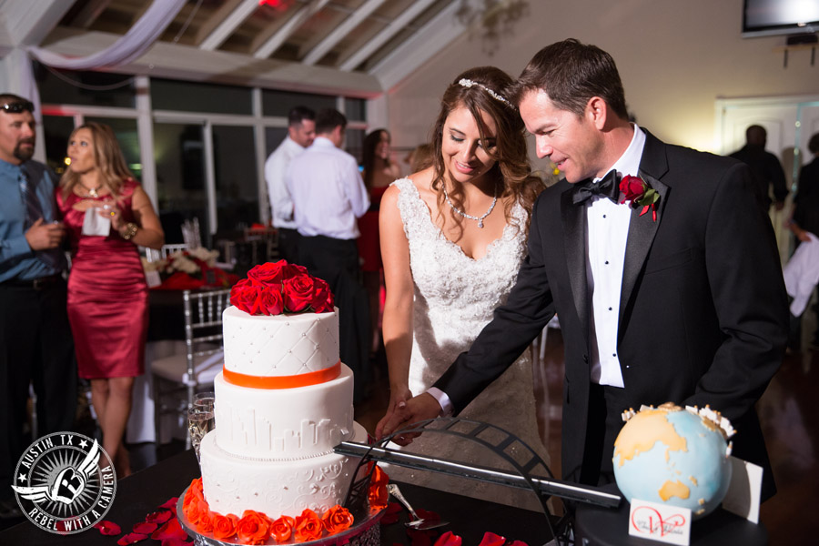 Taylor Mansion wedding photo bride and groom cut bride's cake with red roses and travel globe groom's cake by Sweet Life of Cakes