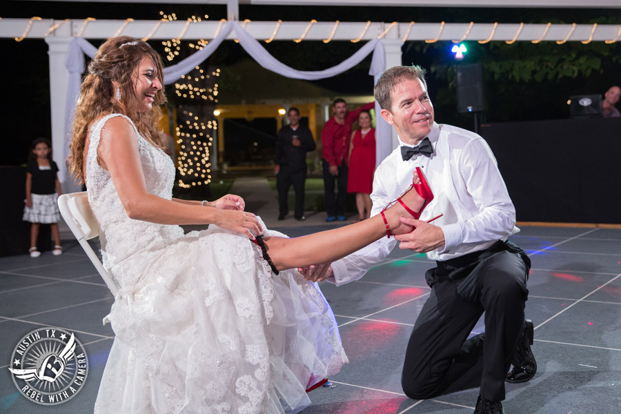 Taylor Mansion wedding photo groom takes garter off bride on the patio with 1st Class Entertainment DJ Jason