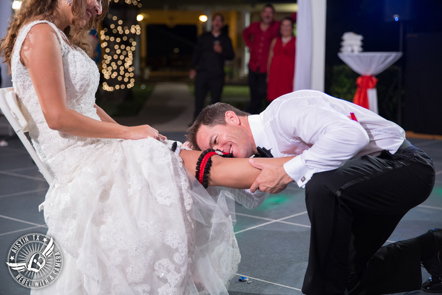 Taylor Mansion wedding photo groom takes garter off bride on the patio with 1st Class Entertainment DJ Jason