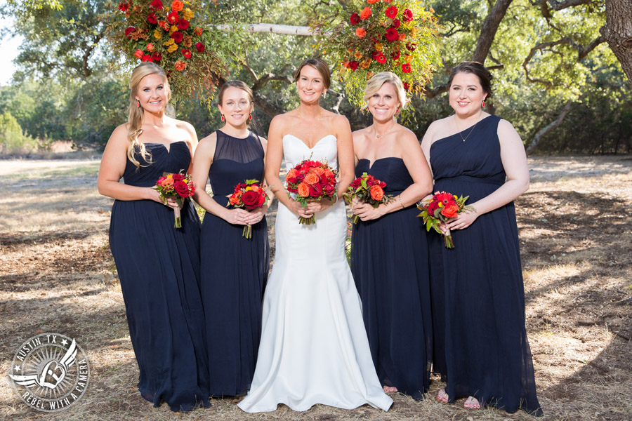 Hamilton Twelve wedding photos - bride and bridesmaids in navy dresses and red and orange bouquets by the Flower Girl
