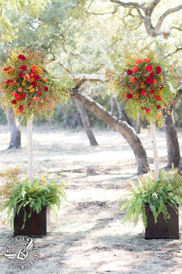 Hamilton Twelve wedding photos - ceremony site birch bark arbor by the Flower Girl with red and orange roses and gerbera daisies