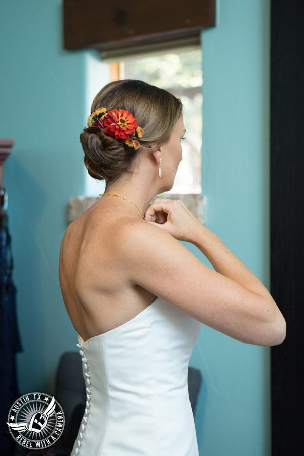 Hamilton Twelve wedding photos - bride straightens necklace in the bride's room - floral updo by Kiss by Katie