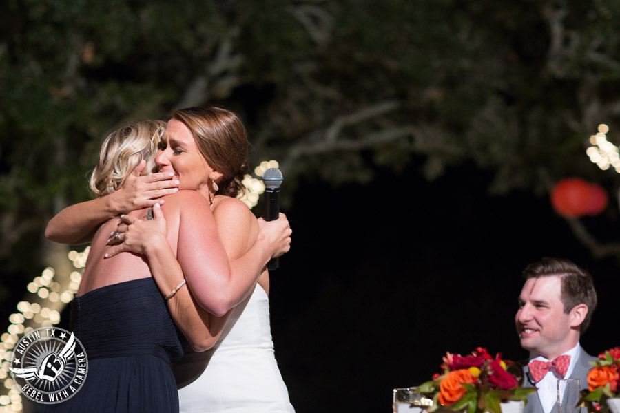 Hamilton Twelve wedding photos - bride hugs bridesmaid during toasts at wedding reception