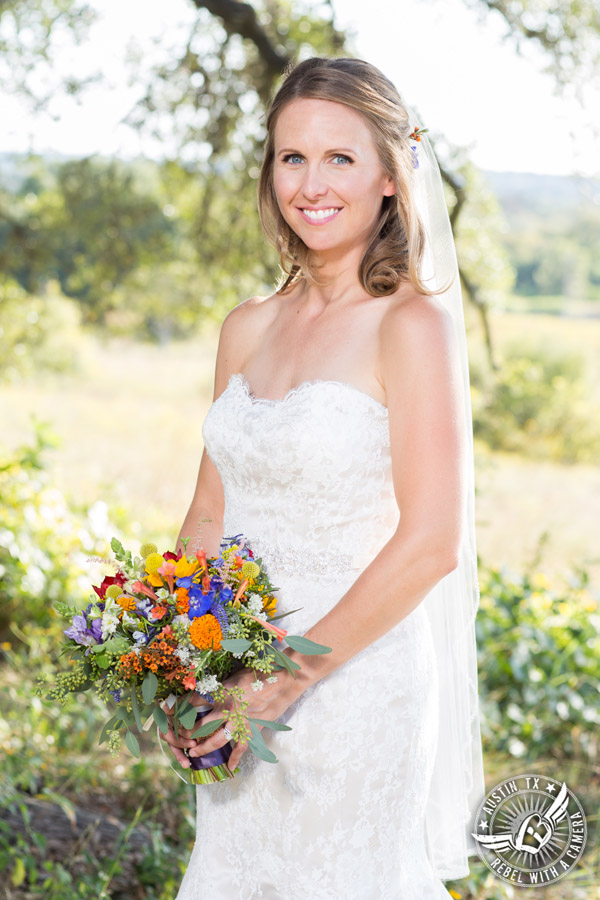 Wedding pictures at Thurman's Mansion at the Salt Lick - bride under the oak trees - colorful wildflower bridal bouquet by Verbena Floral Design - hair and makeup by Topaz Salon