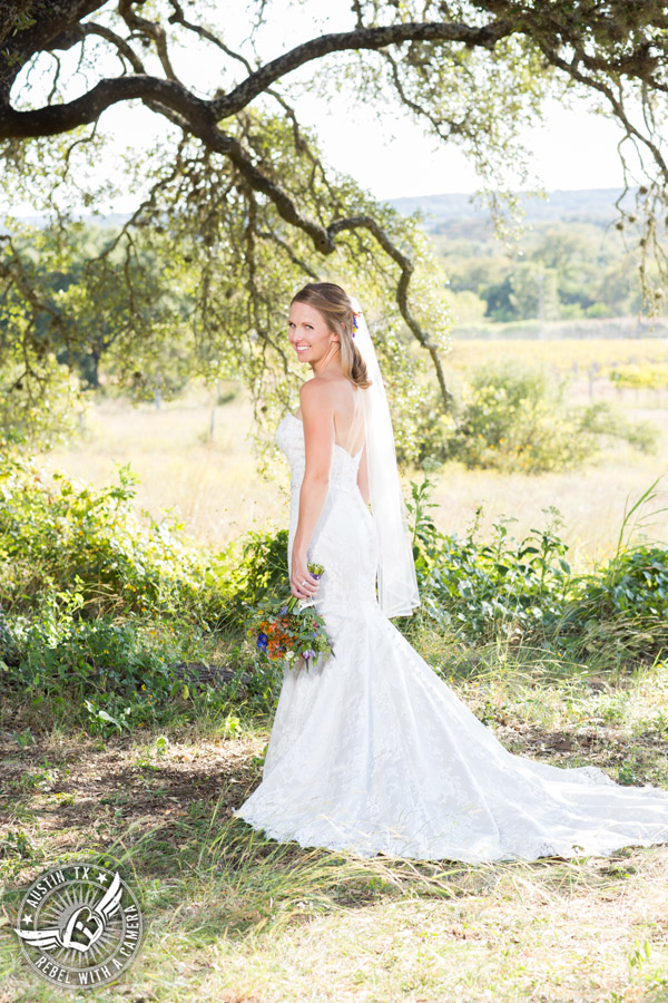 Wedding pictures at Thurman's Mansion at the Salt Lick - bride under the oak trees - colorful wildflower bridal bouquet by Verbena Floral Design - hair and makeup by Topaz Salon