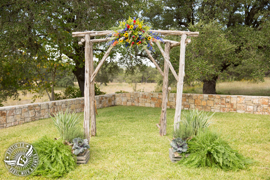 Wedding pictures at Thurman's Mansion at the Salt Lick - colorful wildflower arbor at the ceremony site by Verbena Floral Design