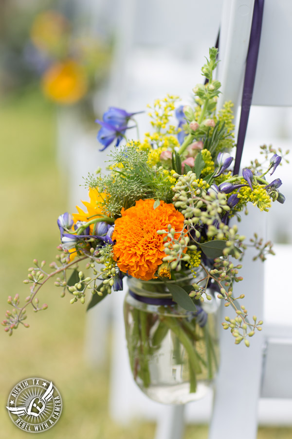 Wedding pictures at Thurman's Mansion at the Salt Lick - colorful wildflower ceremony aisle floral decor in mason jars by Verbena Floral Design