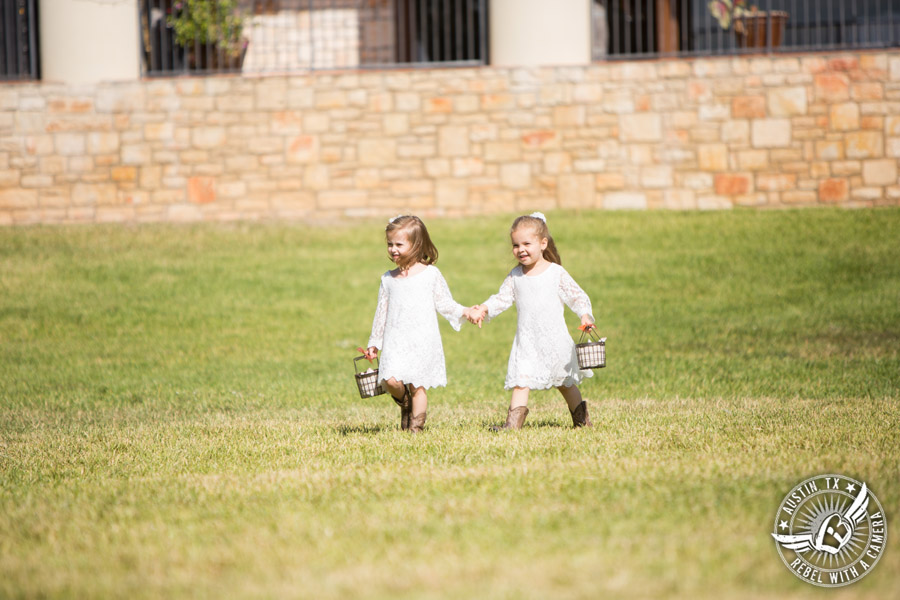 Wedding pictures at Thurman's Mansion at the Salt Lick - flower girls in lace dresses and cowboy boots walk to the ceremony