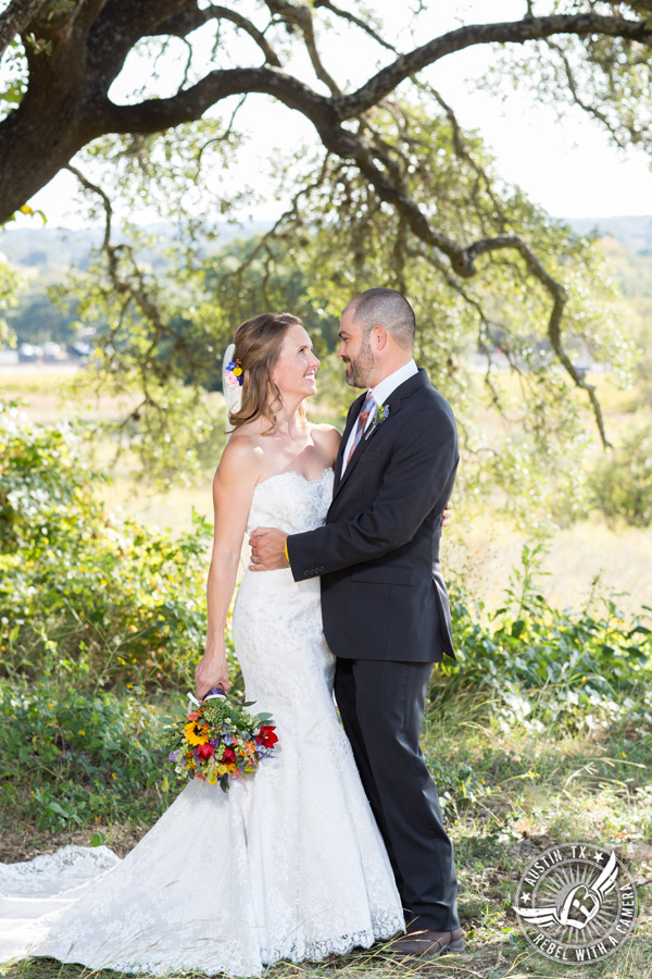 Wedding pictures at Thurman's Mansion at the Salt Lick - bride and groom look at each other under the oak trees