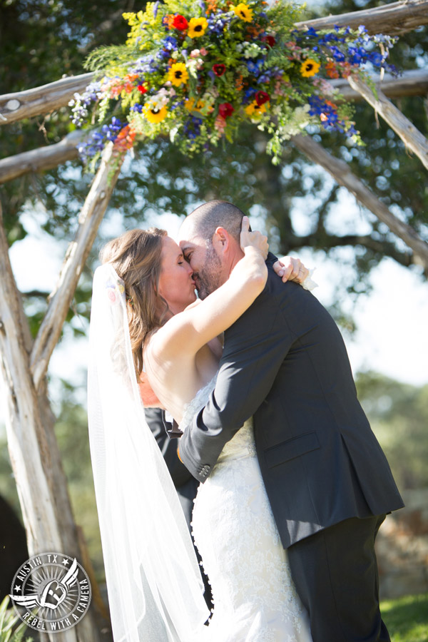 Wedding pictures at Thurman's Mansion at the Salt Lick - bride and groom kiss during the wedding ceremony