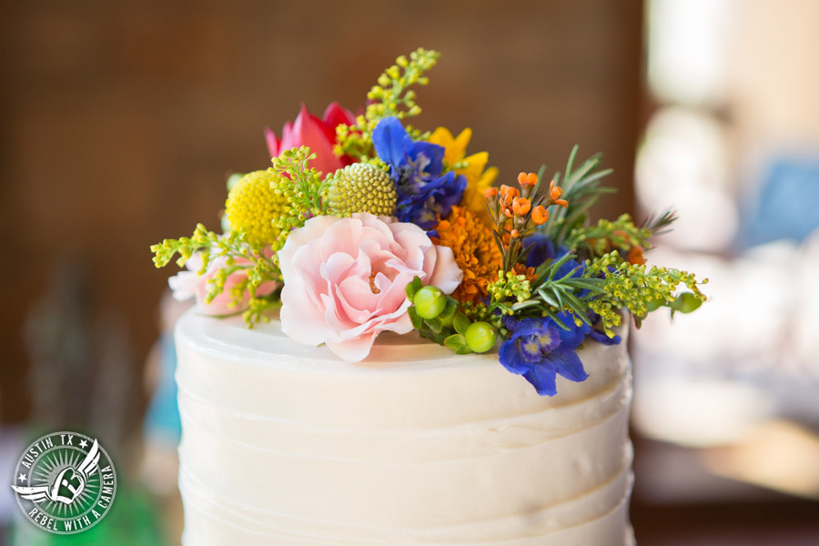 Wedding pictures at Thurman's Mansion at the Salt Lick - white buttercream bride's wedding cake Sweet Treets Bakery with colorful wildflowers by Verbena Floral Design