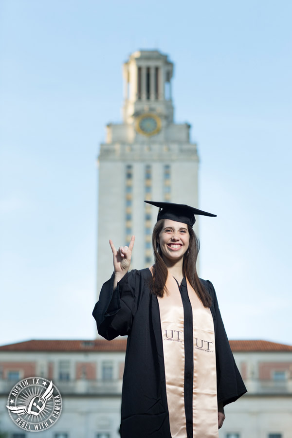 Longhorn graduation pictures on the UT Austin campus - graduate in cap and gown in front of the UT tower