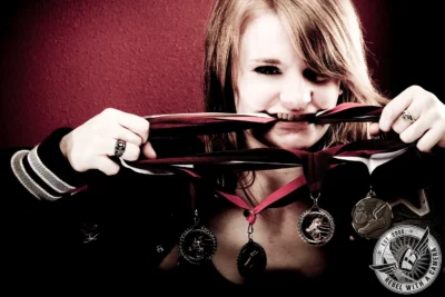 Red-haired senior holding a letterman jacket ribbon in Austin, TX.
