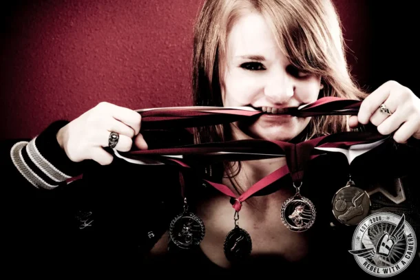 Red-haired senior holding a letterman jacket ribbon in Austin, TX.