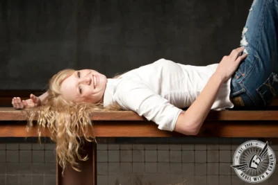 MSSL senior portrait of a blonde girl lying on a wooden bench