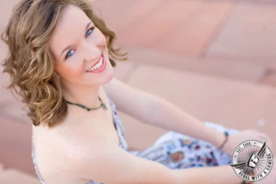 Austin senior portrait close-up of a smiling woman in a patterned dress in Austin, TX.