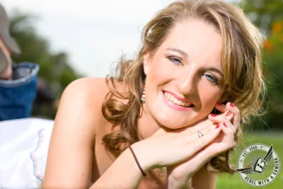 Austin senior portrait close-up of a smiling woman outdoors at Mueller Lake Park in Austin, TX.