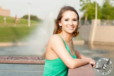 Austin senior portrait of a smiling woman in a turquoise dress at Lady Bird Lake in Austin, TX.