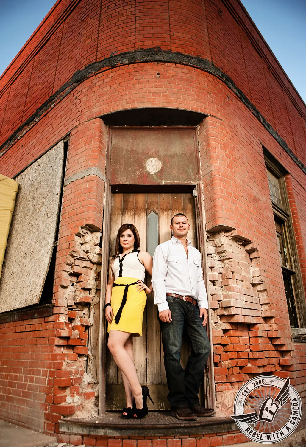 Couple posing in the doorway of an old brick building in Austin, TX.