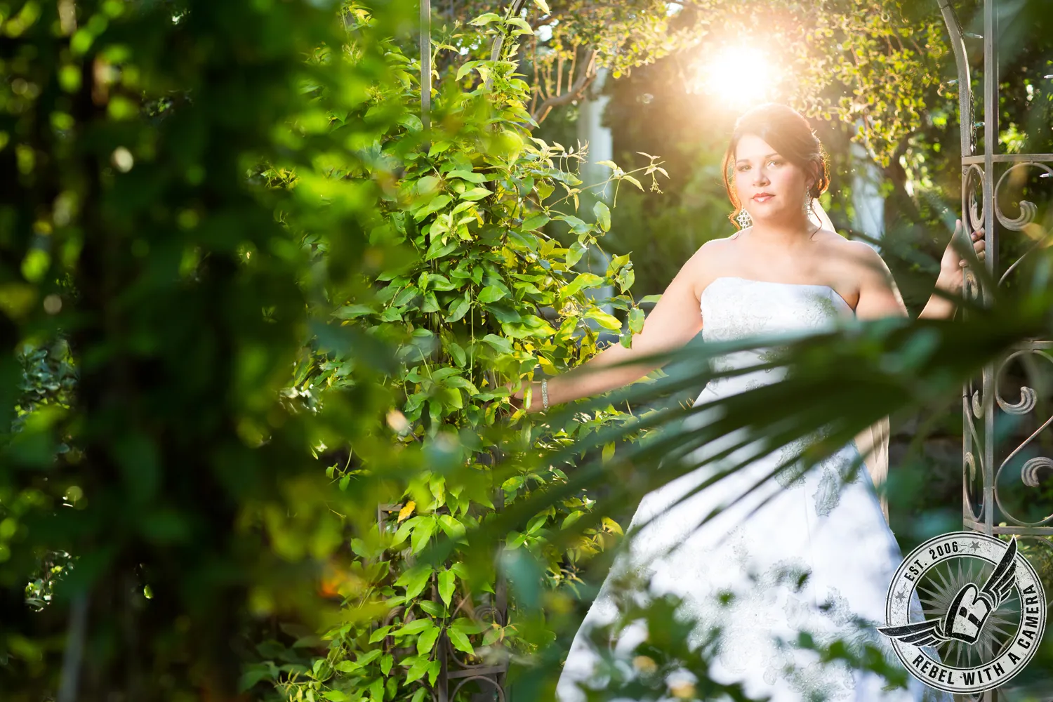 Bride in a strapless wedding gown posing among leafy greenery in Austin, Texas.