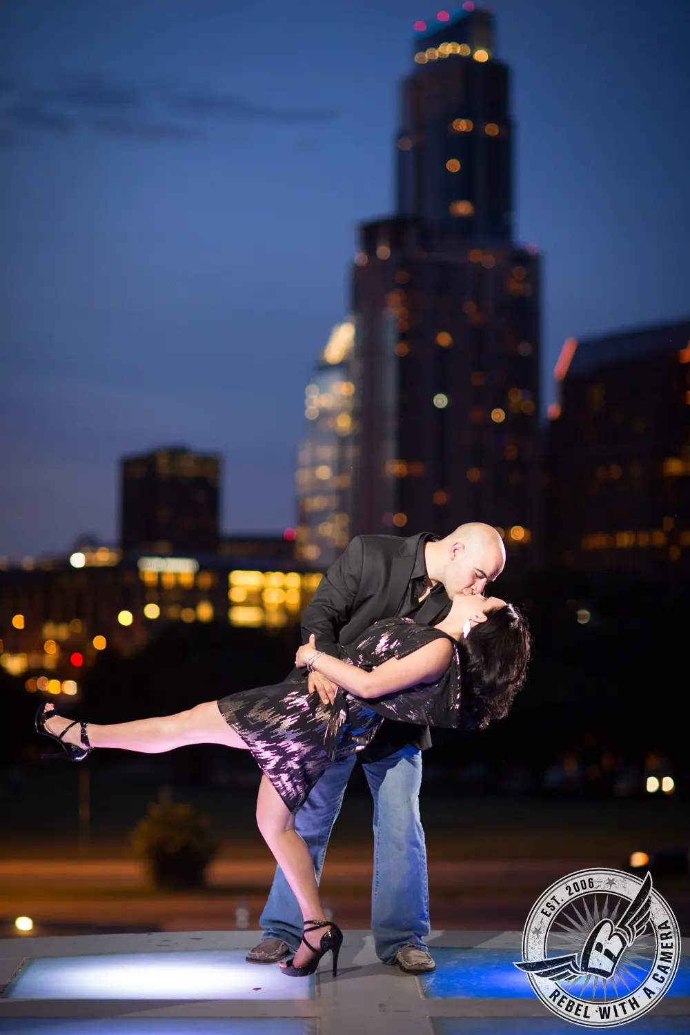 Couple kissing in a city plaza at night in Austin, TX.