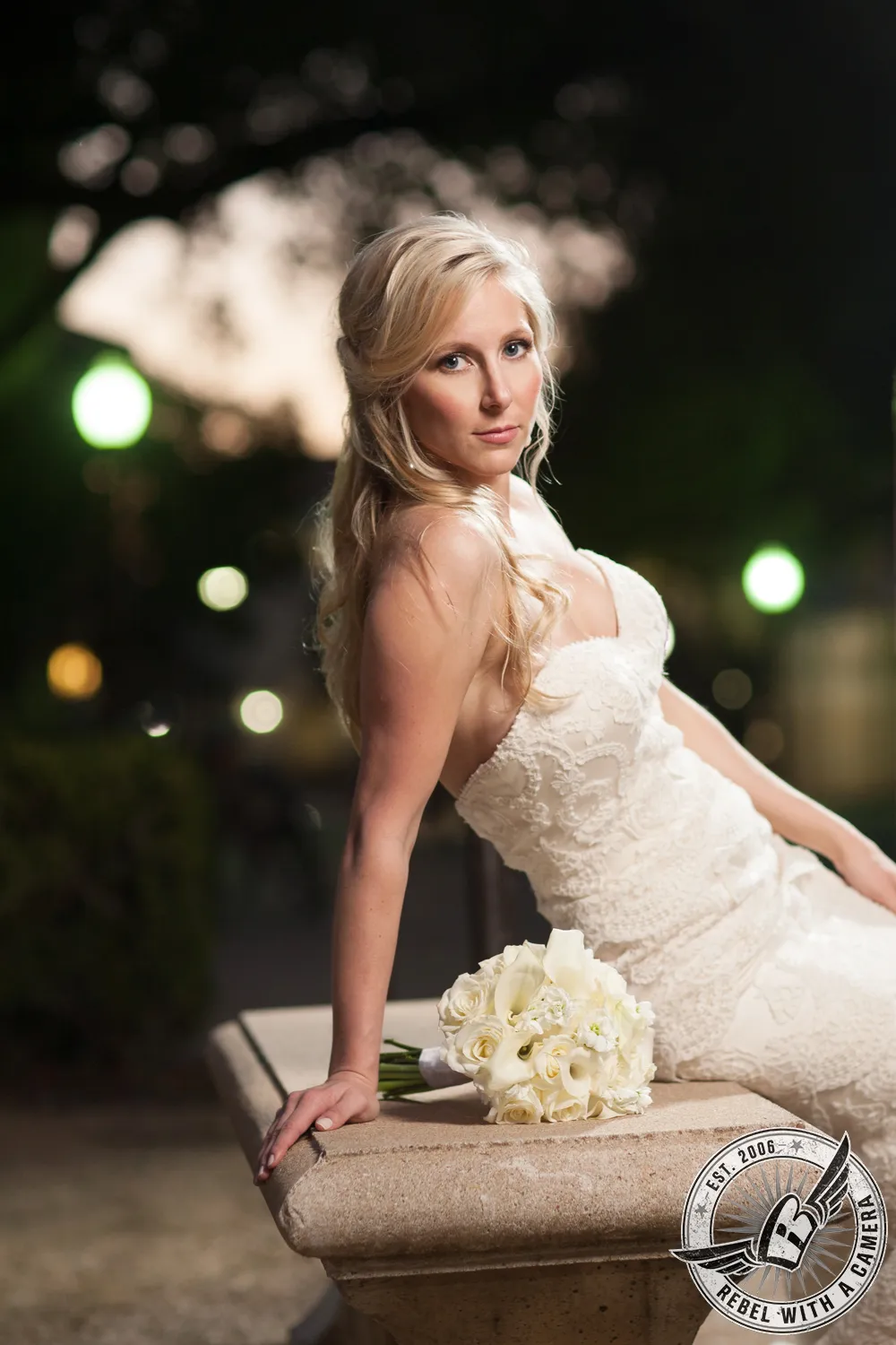 Bride in a white lace dress posing with a bouquet in Austin, Texas.
