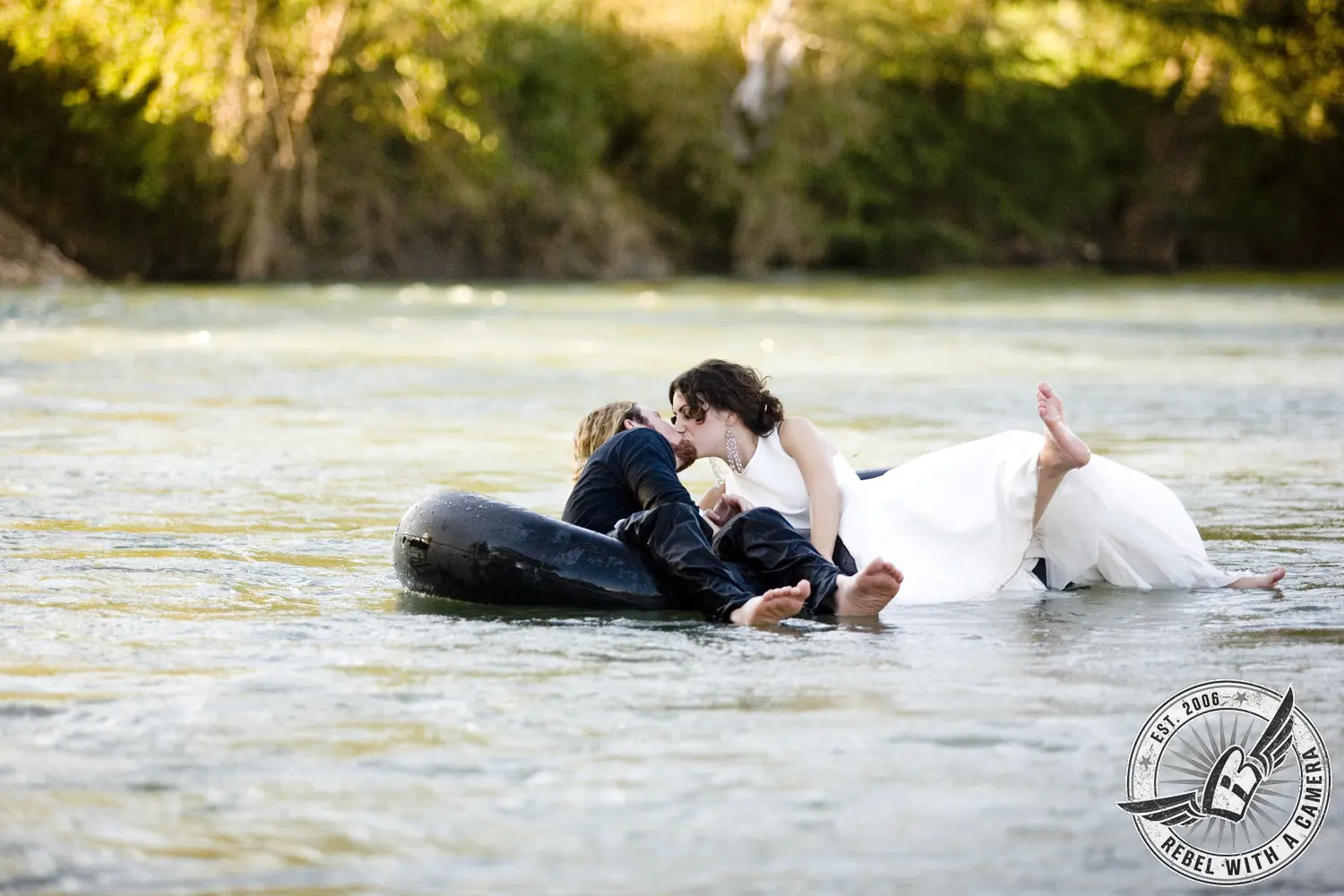 Couple kissing while floating on an inner tube in a river