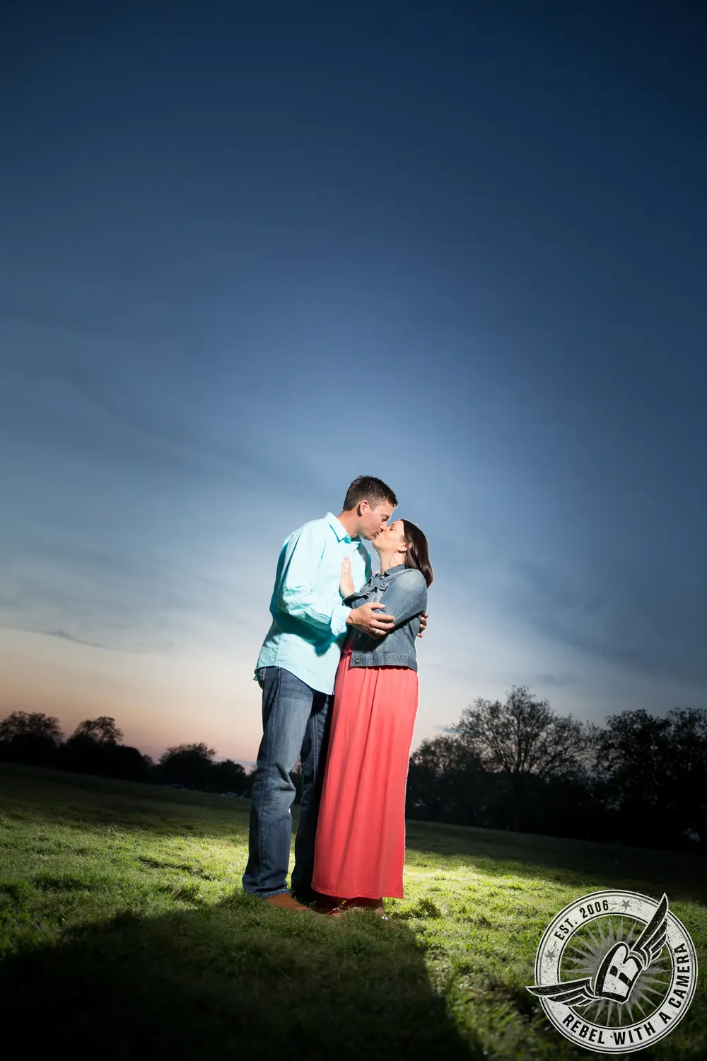 Couple kissing in a sunlit grassy field in Austin, TX.
