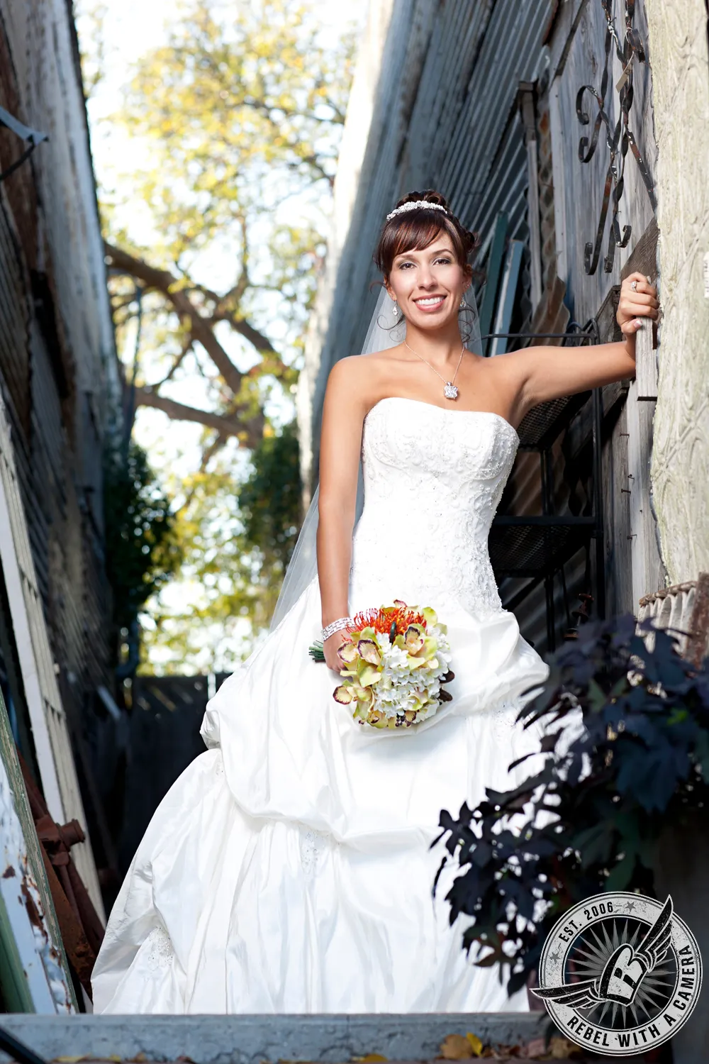 Bride in a white wedding dress and veil holding a bouquet in an outdoor setting in Austin, TX.