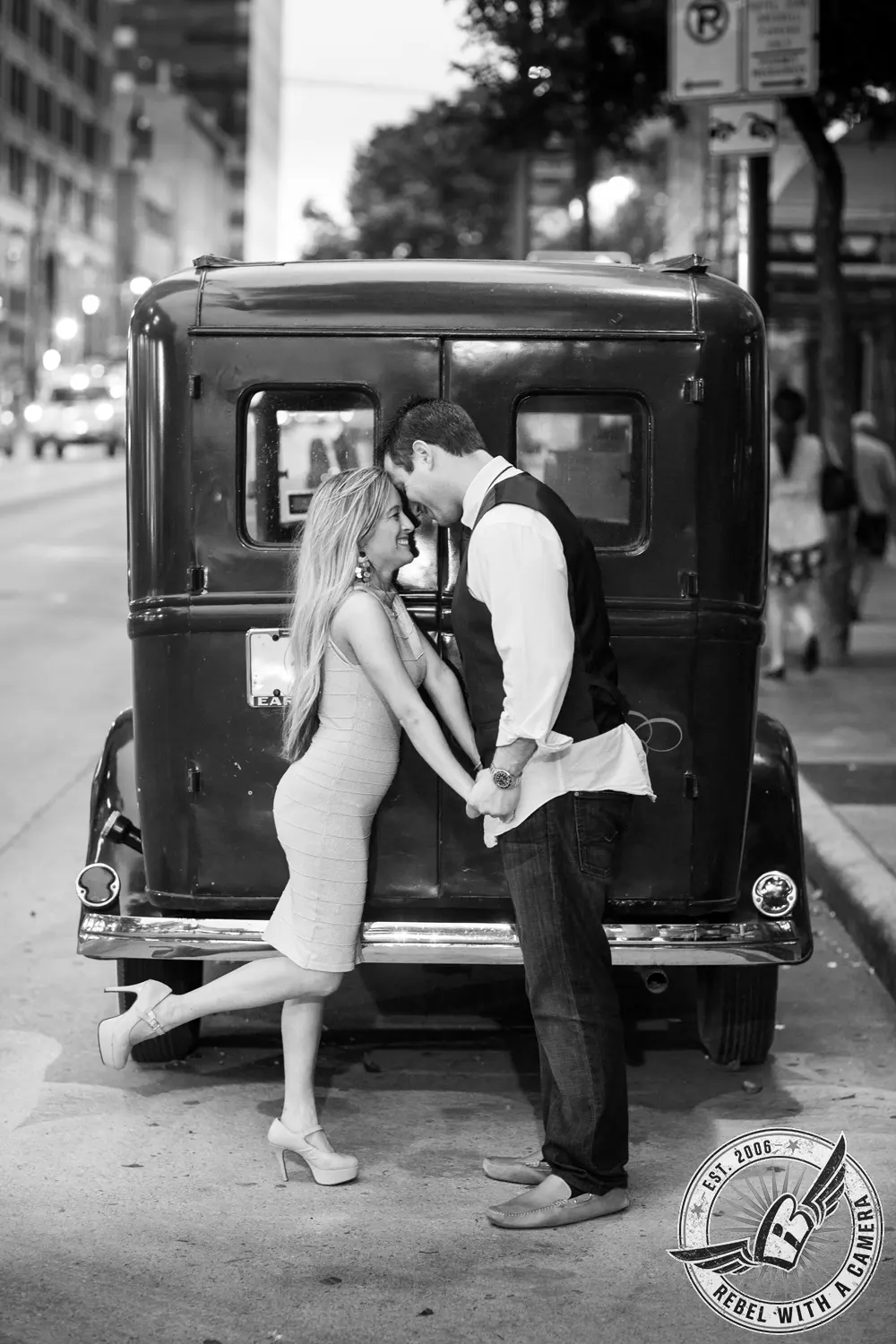 Black and white couple kissing in front of a vintage vehicle in Austin, TX.