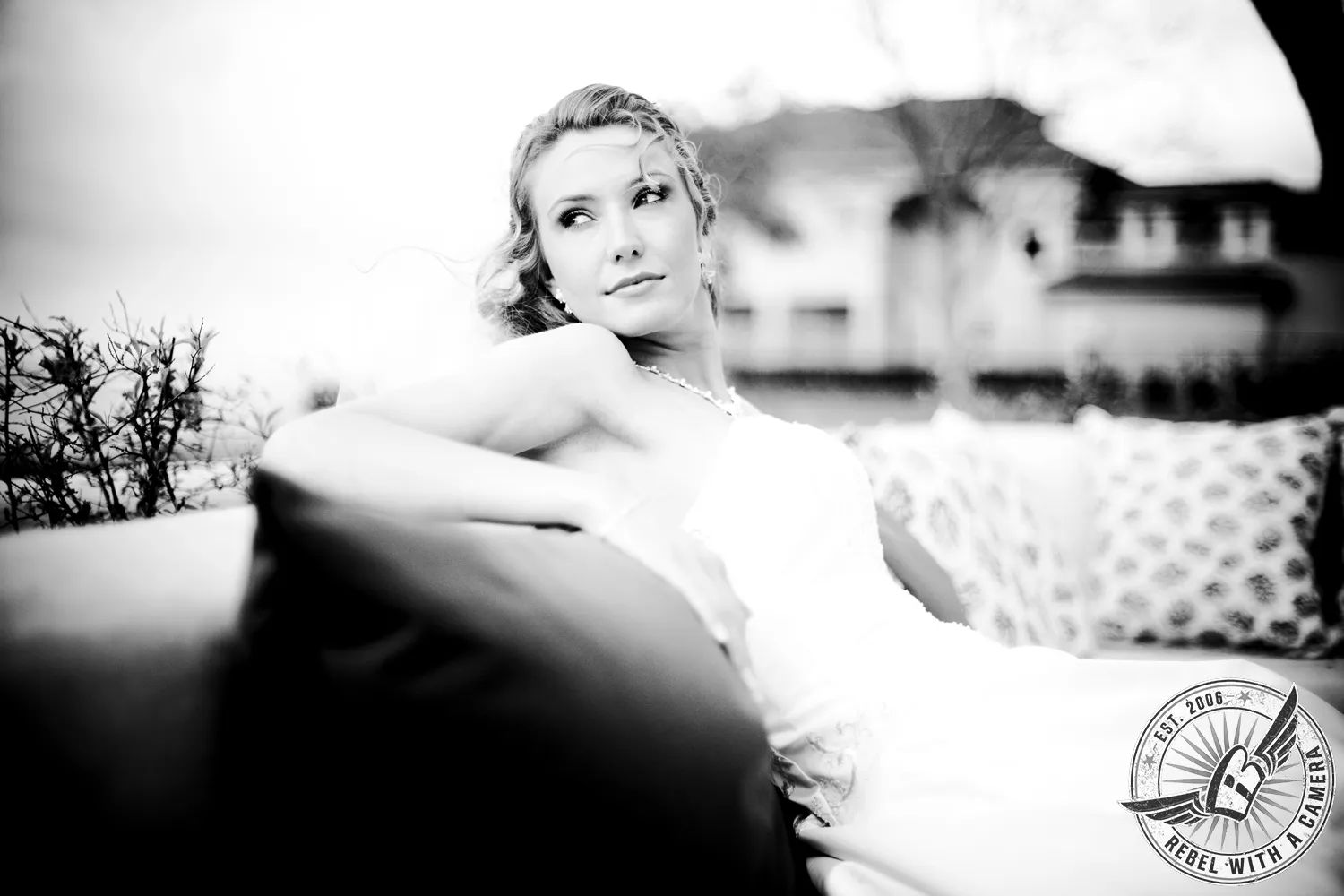 Black-and-white portrait of a blonde bride reclining on a sofa in Austin, TX.