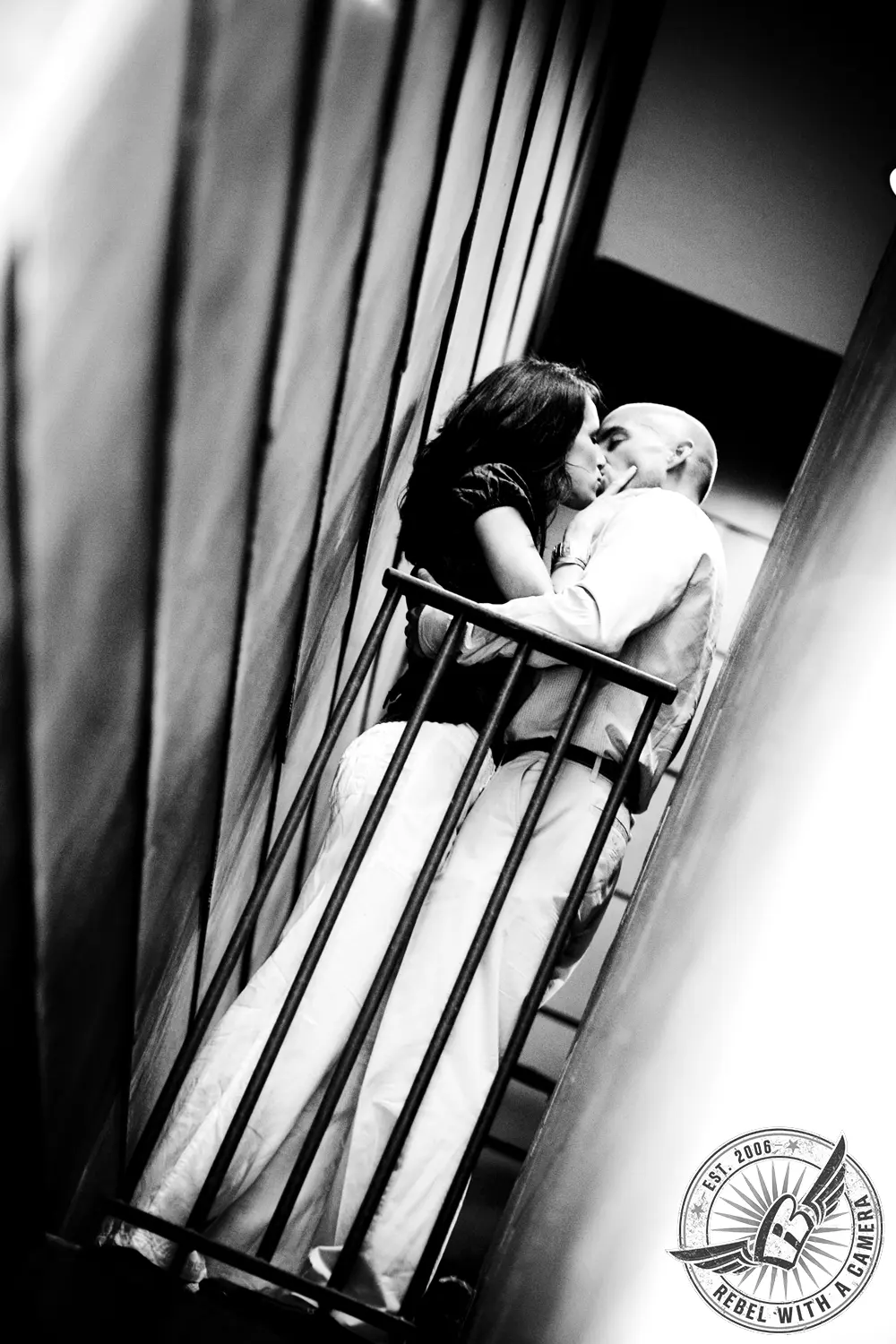 Black and white couple kissing beside tall architectural beams