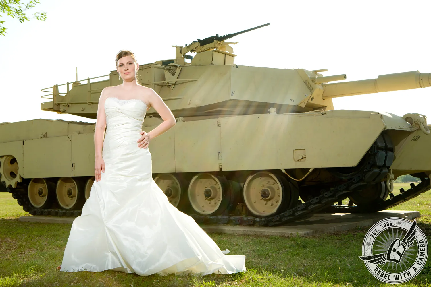 Bride in a white wedding dress posed in front of a military tank in Austin, TX.