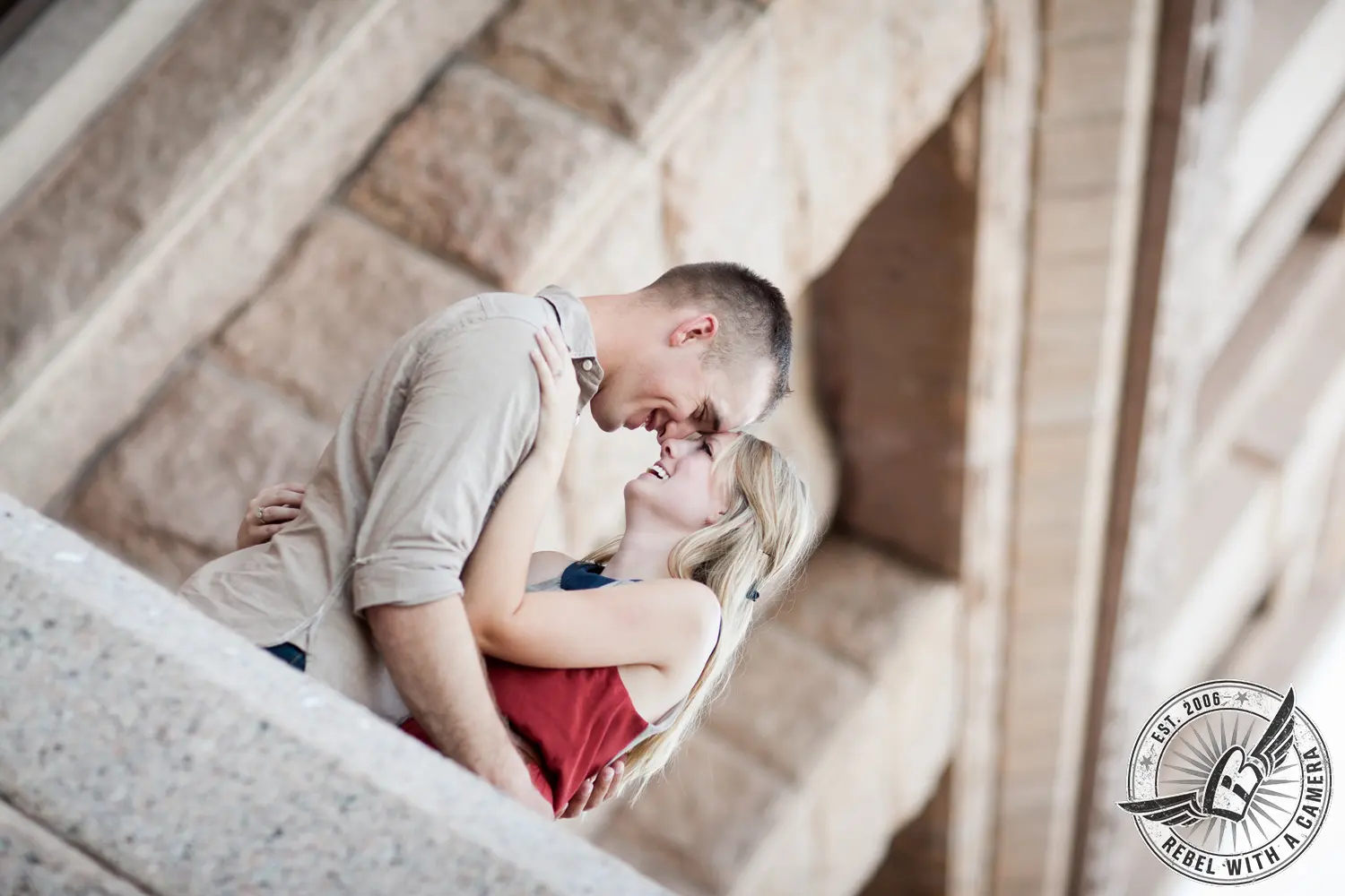Couple laughing together beneath a stone structure
