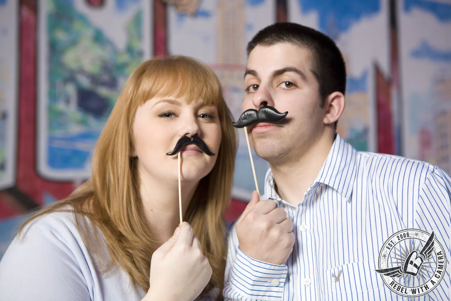Couple posing with novelty mustache props
