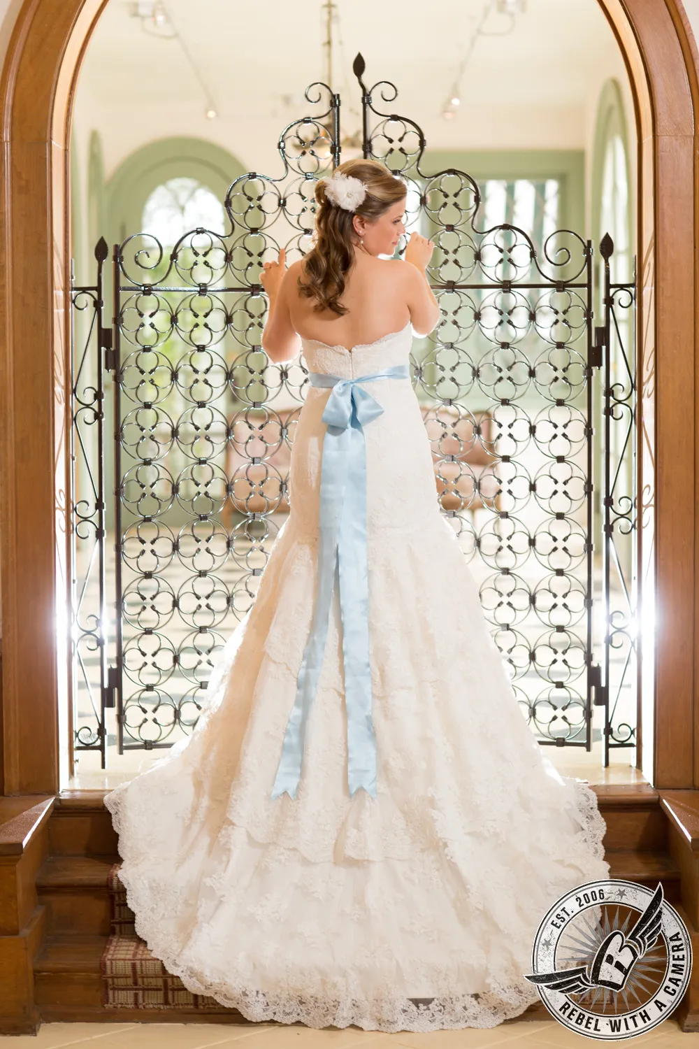 Bride in a white wedding dress standing before an ornate window in Austin, Texas.
