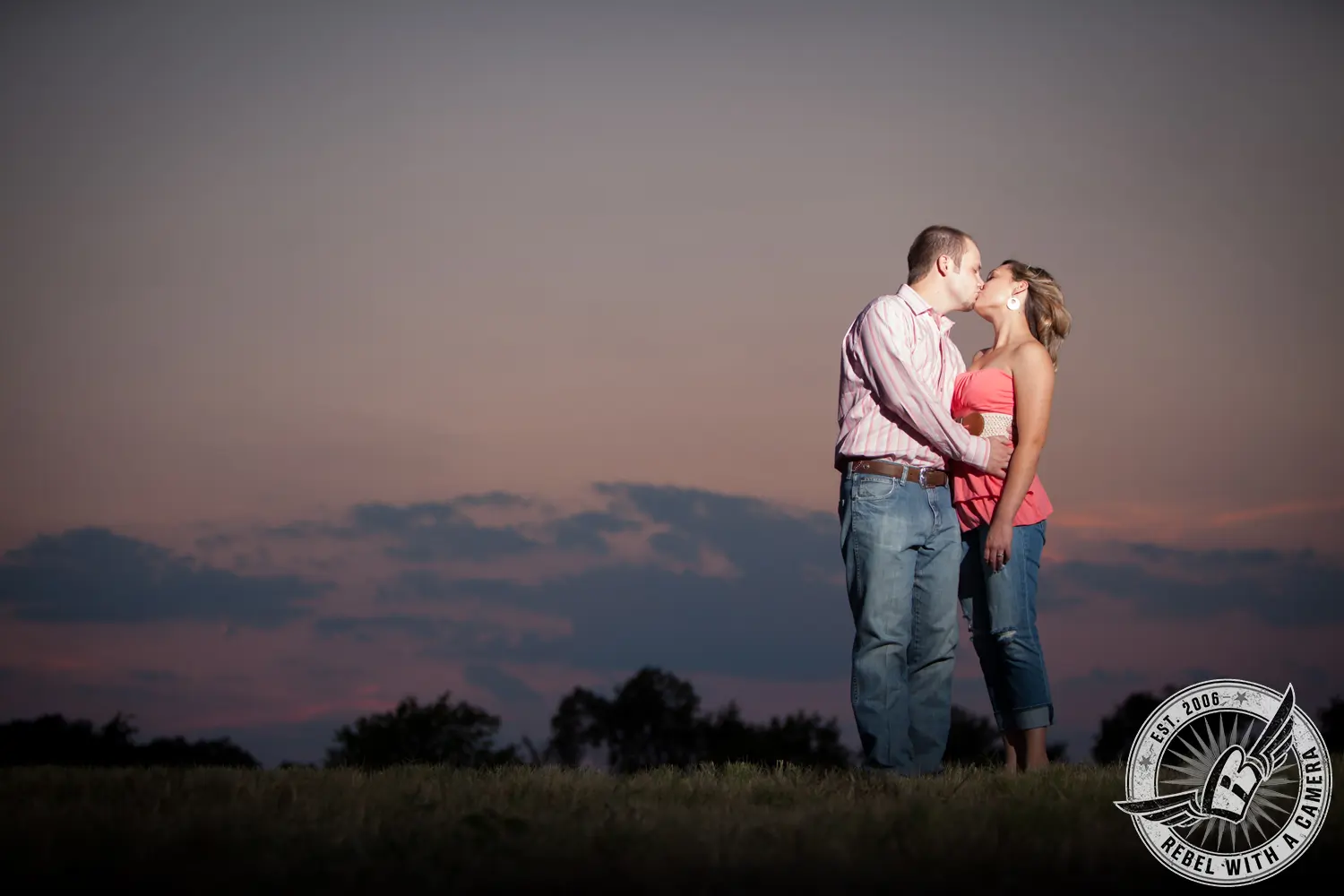 Couple kissing in an open field at dusk in Austin, TX.